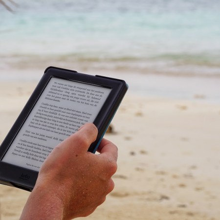 reading a book on a tablet on the beach