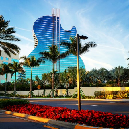 hotel in florida shaped as a guitar, with palms and a blue sky