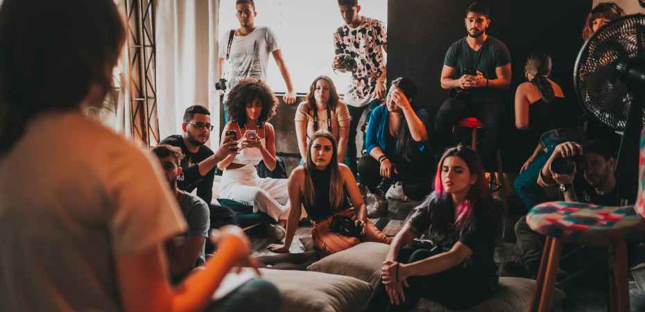 group of multiethnic people gathering around female speaker in studio