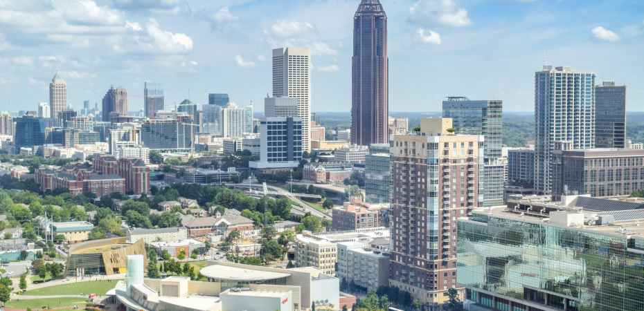 high rise buildings near green trees under blue sky