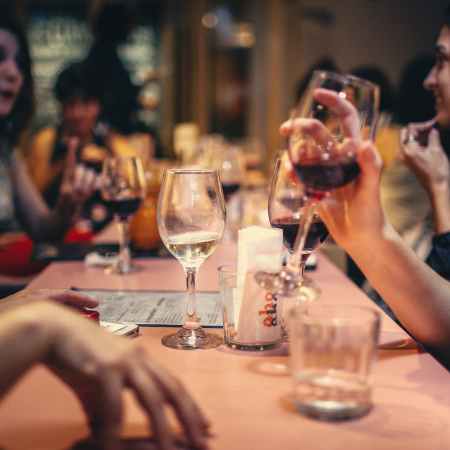 people drinking liquor and talking on dining table close up photo