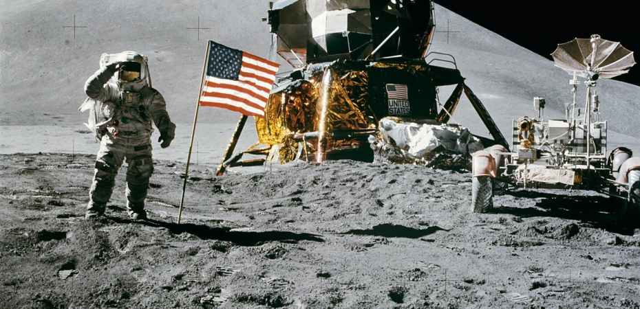 astronaut standing beside american flag on the moon
