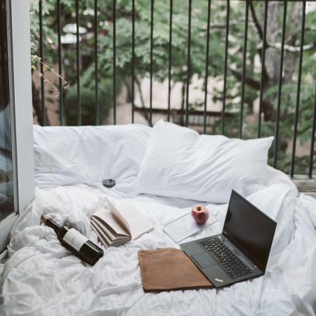 laptop on bed near the balcony
