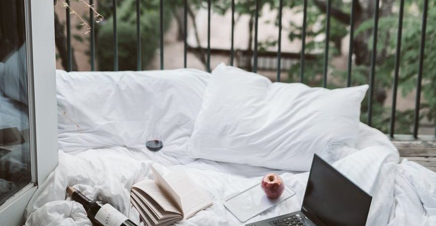 laptop on bed near the balcony